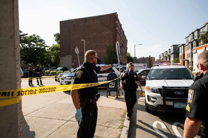 Police officers secure an urban street with yellow tape near patrol cars