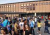 Students gathered outside a school building entrance