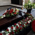 Coffin with floral arrangements at a funeral service