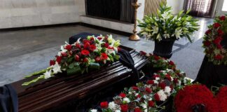 Coffin with floral arrangements at a funeral service