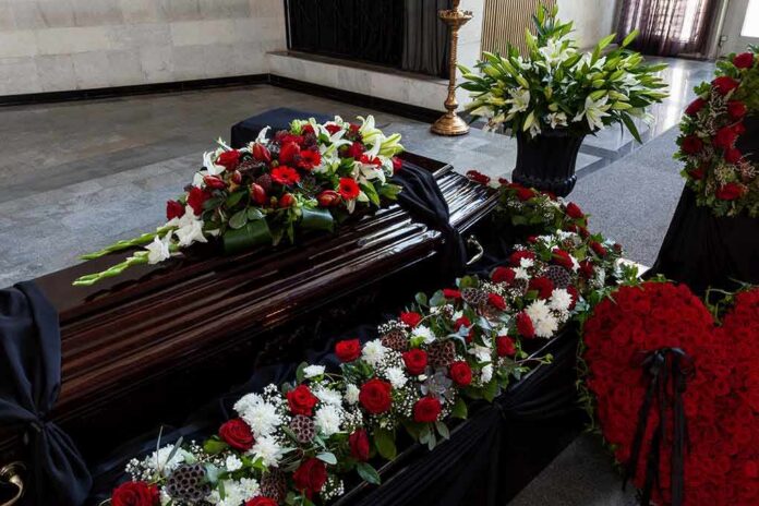 Coffin with floral arrangements at a funeral service