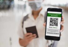 person holding smartphone showing vaccination certificate QR code
