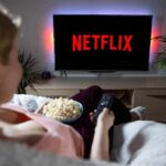 person watching tv with popcorn in a cozy living room