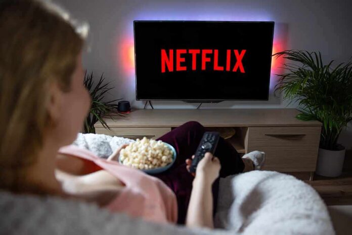 person watching tv with popcorn in a cozy living room