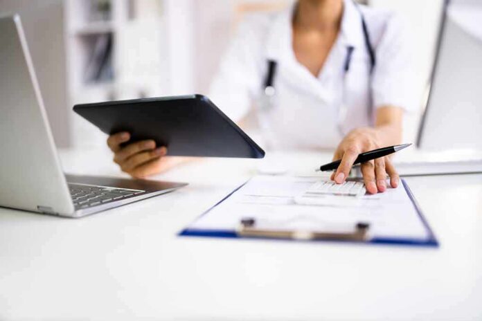 Healthcare worker using tablet and filling out form