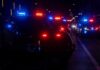 Police vehicles with flashing red and blue lights at night
