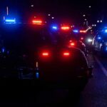 Police vehicles with flashing red and blue lights at night