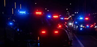Police vehicles with flashing red and blue lights at night