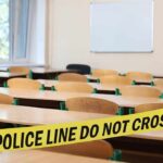 Empty classroom with police tape across desks