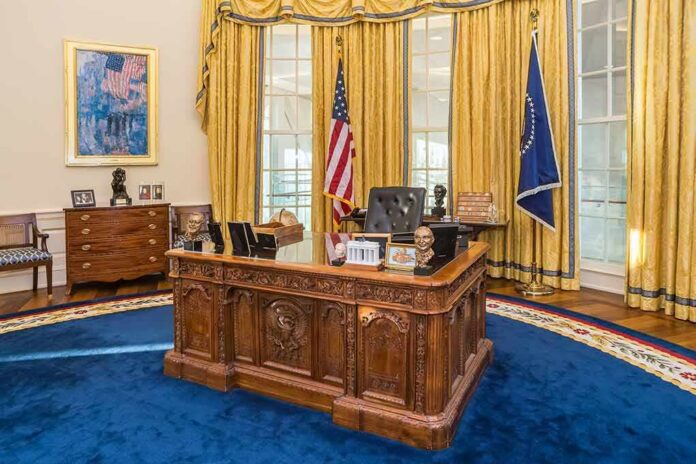Ornate wooden desk in a grand office with gold curtains and flags