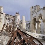 Interior view of a destroyed building with collapsed arches and debris