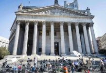 Reporters and photographers gathered outside a neoclassical courthouse