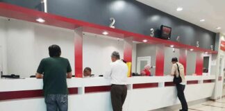 People at numbered service counters in a modern lobby