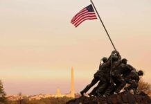 Iwo Jima Memorial with soldiers raising the American flag at sunset