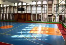 Indoor basketball court with blue floor and orange key areas