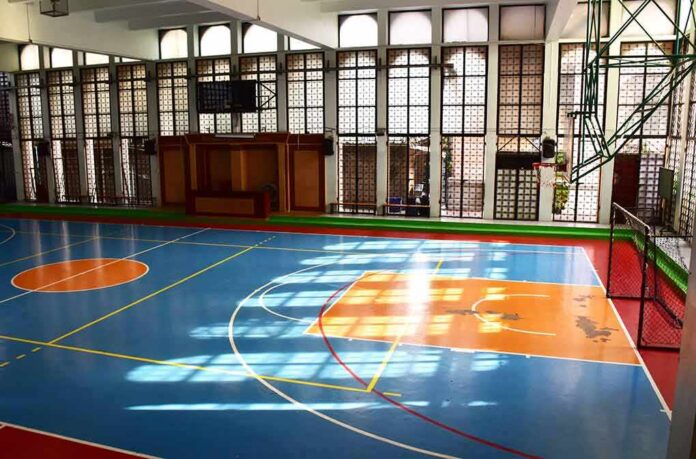 Indoor basketball court with blue floor and orange key areas