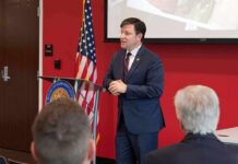 Probable Cause – Explosive Omar Inquiry Speaker in a navy suit addressing an audience at a podium
