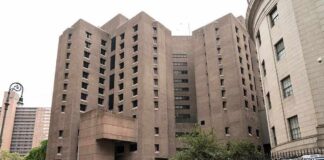 Brutalist high-rise detention facility on a city street