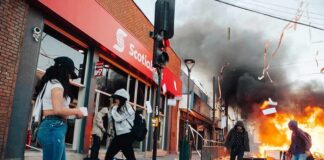 Street protest with fire and smoke outside a bank