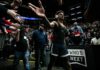 Basketball player in arena high-fives fans while wearing headphones
