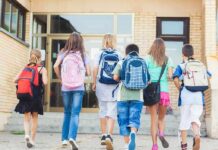 Backpack Bomb Horror On School Hike Group of children walking towards a school entrance with backpacks