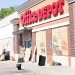 Office supply store with boarded windows and graffiti