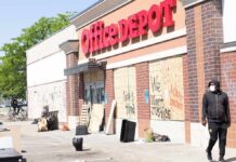 Office supply store with boarded windows and graffiti