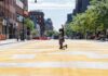 Person kneeling on painted city street raising fist