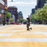 Person kneeling on painted city street raising fist