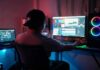 Person editing video at dual-monitor PC with RGB lights