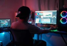 Person editing video at dual-monitor PC with RGB lights