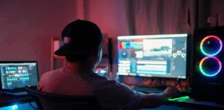 Person editing video at dual-monitor PC with RGB lights
