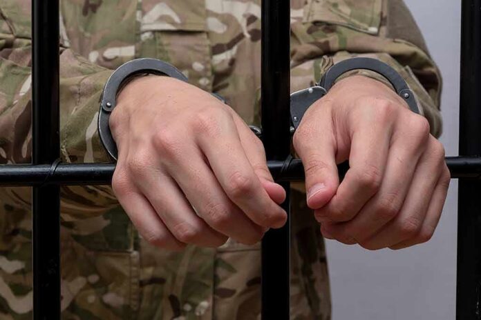 shutterstock_2206106757 Hands in handcuffs gripping jail bars