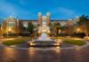 Historic brick university building with central fountain at dusk