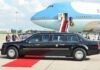Presidential limousine beside a large blue-and-white jet on a runway