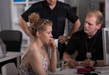 Young woman speaking with two officers at a desk