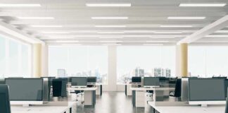 Open-plan office with rows of desks and monitors