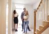 Nick Nanton and a couple with a baby tour a bright home entryway