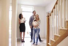 Nick Nanton and a couple with a baby tour a bright home entryway