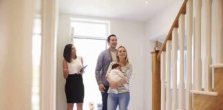 Nick Nanton and a couple with a baby tour a bright home entryway