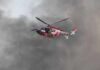 Rescue helicopter hovers amid thick smoke