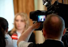 tv camera films interview with blurred speaker